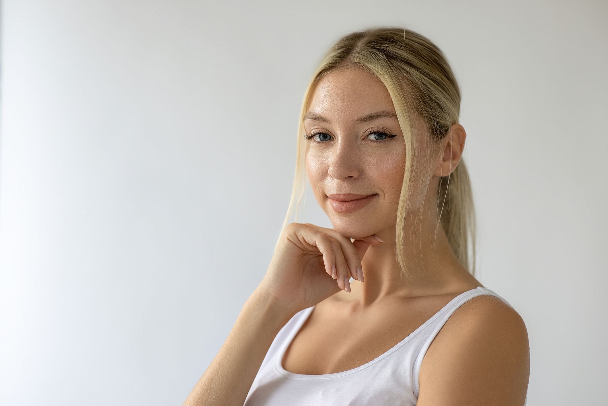 Smiling woman with blonde hair in white top.